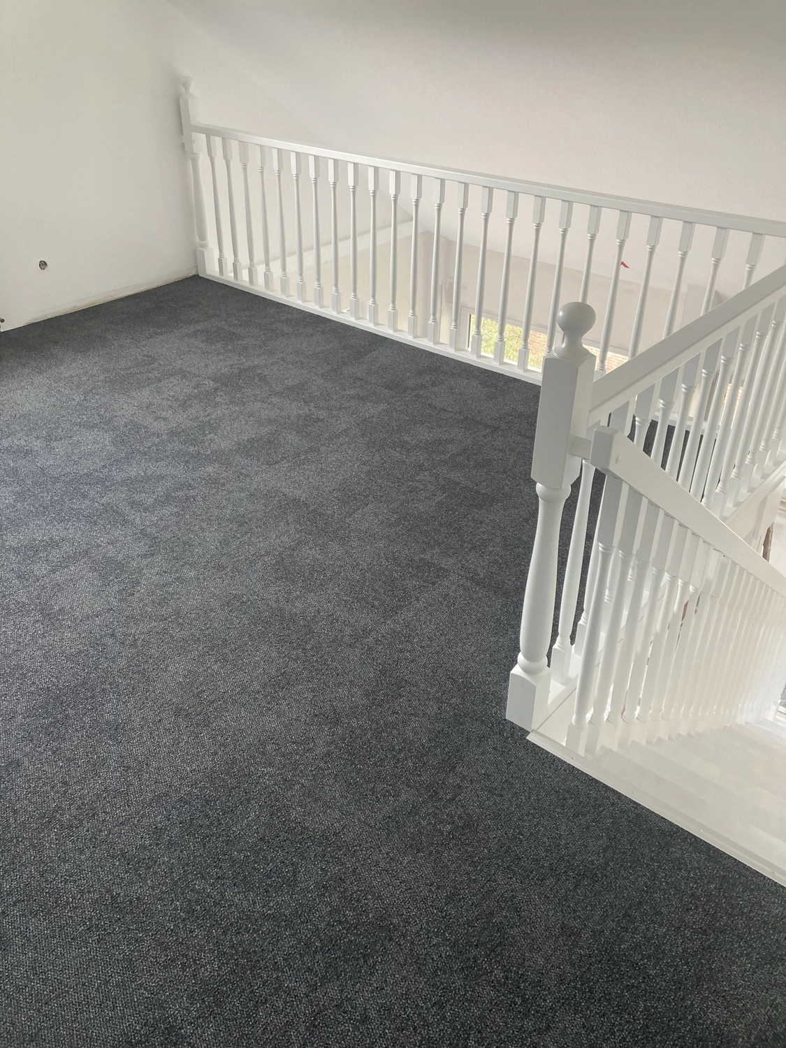 Toni´s Farbenspiel Malermeister - Malermeister - ein neu mit Teppich ausgelegter Treppenabsatz und Treppenhaus mit weißem Geländer.