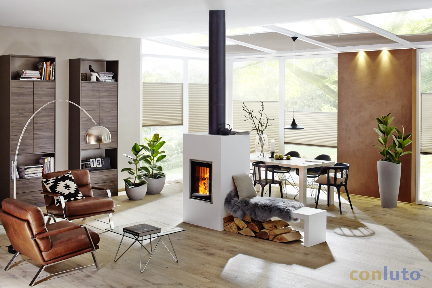 Toni´s Farbenspiel Malermeister - Malermeister - ein moderner Wohnraum mit zentralem Kamin und verschiedenen Möbelstücken der Marke conluto