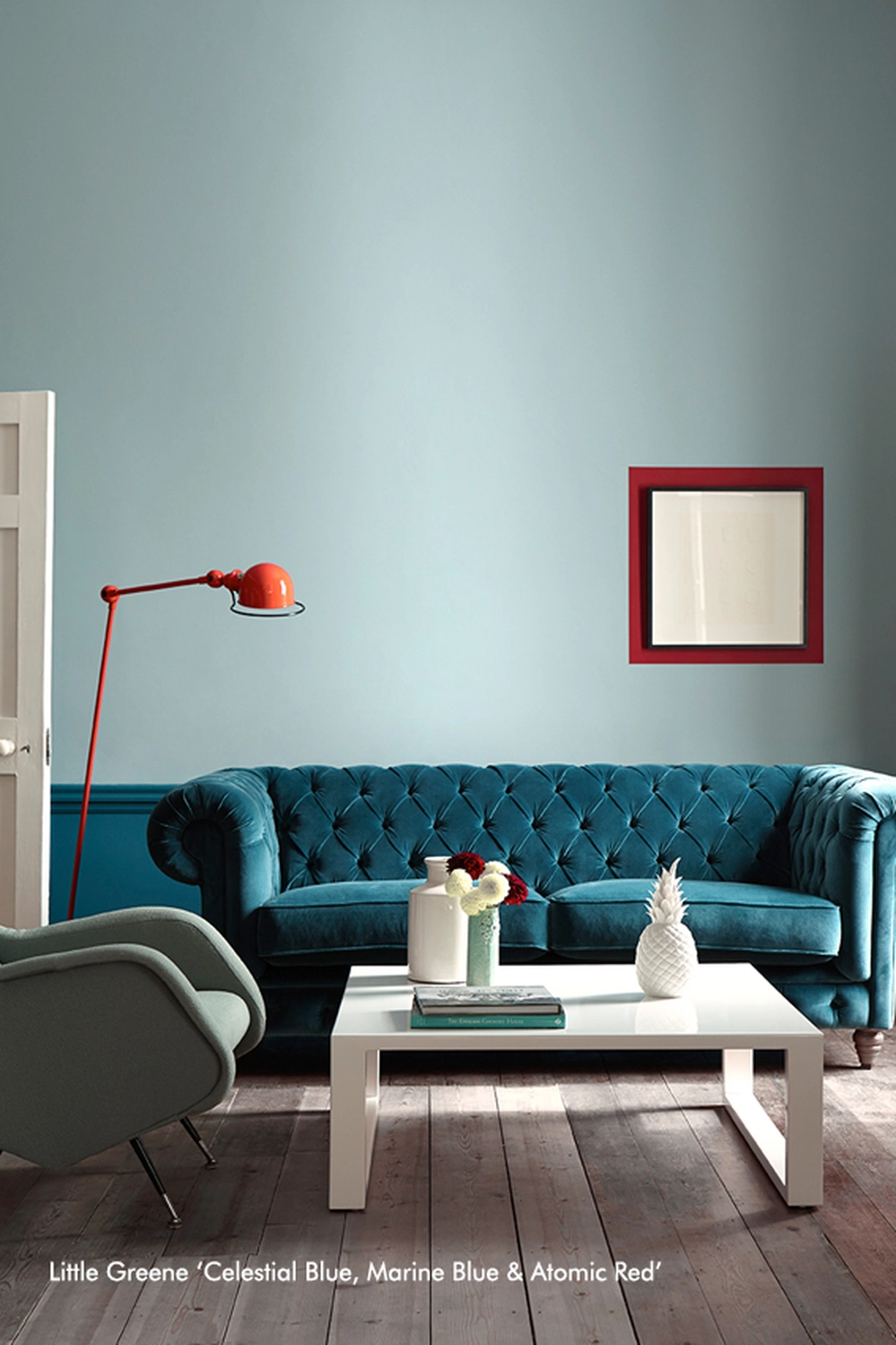 Tonis Farbenspiel Malermeister – Malermeister – das Bild beschreibt einen Wohnraum, der mit einem bestimmten Farbschema der Farbenfirma Little Greene dekoriert ist, mit himmelblauen Wänden, marineblauer Täfelung und einem Atomrot-Akzent.